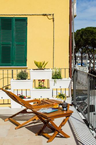 a wooden picnic table on a balcony with a yellow building at La Posta Di Cadimare - Chill in the Mezzanine Bedroom at a Former Post Office in Fezzano