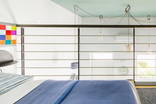 a bedroom with a bed and a glass wall at La Posta Di Cadimare - Chill in the Mezzanine Bedroom at a Former Post Office in Fezzano