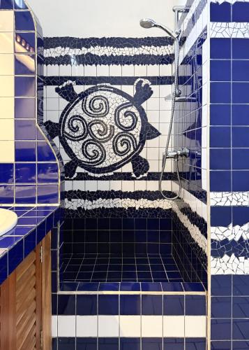 a blue tiled bathroom with a turtle on the wall at Palm villa Mirissa hotel&spa in Mirissa