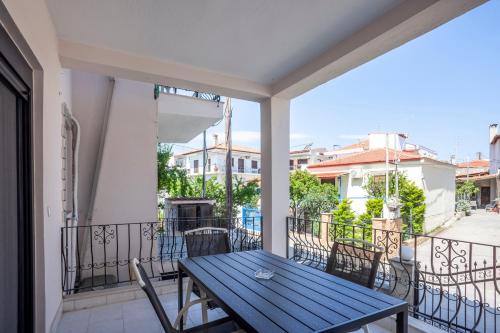 a balcony with a wooden table and chairs at Old Square House in Pefkochori