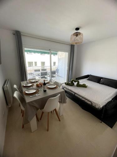 a room with a table and a bed and a table and chairs at Apartament Mar Beach Lloret II Aqua in Lloret de Mar