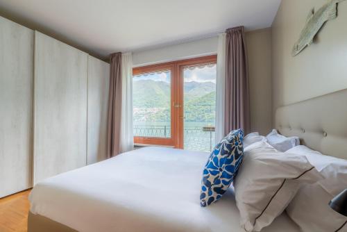 BriennoにあるVilla Glicine, by R Collection apartmentのベッドと大きな窓のある寝室