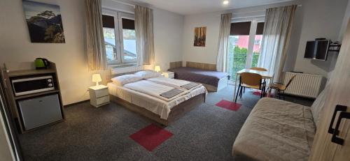 a bedroom with a bed and a couch and a table at Dom Goscinny Skarpa in Krynica Zdrój