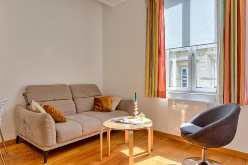 un salon avec un canapé, une table et une chaise dans l'établissement Virginie F2 central et agréable avec parking !, à Rouen