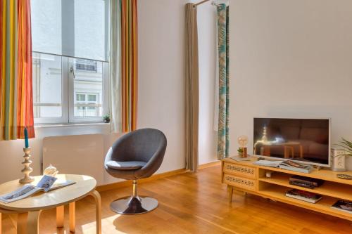 un salon avec une chaise et une télévision dans l'établissement Virginie F2 central et agréable avec parking !, à Rouen