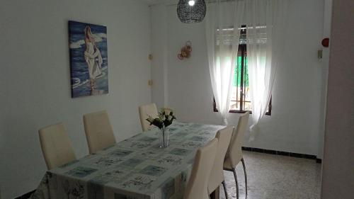 ein Esszimmer mit einem Tisch und einer Blumenvase darauf in der Unterkunft ALOJAMIENTO RURAL CASA LOS ARENALES in Córdoba