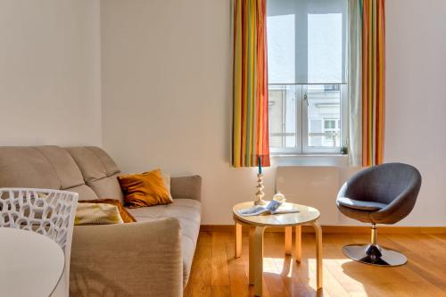 un salon avec un canapé et une chaise dans l'établissement Virginie F2 central et agréable avec parking !, à Rouen