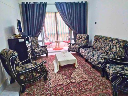 a living room with a couch and chairs and a table at Gadou Rooms in Port Said
