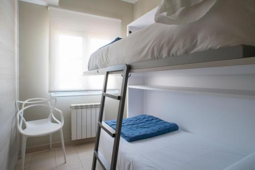 1 dormitorio con 2 literas y 1 silla en Apartaments Turístics Cardona II, en Cardona