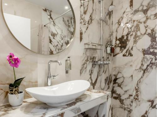 une salle de bain avec un lavabo et un miroir dans l'établissement Merveil -Luxury Serviced Apartment-Saint Martin II, à Paris