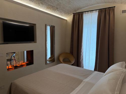 a bedroom with a bed and a tv and a window at Victory Suite in Monopoli
