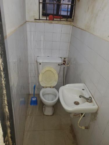 a small bathroom with a toilet and a sink at Zaddy Room in Ikorodu