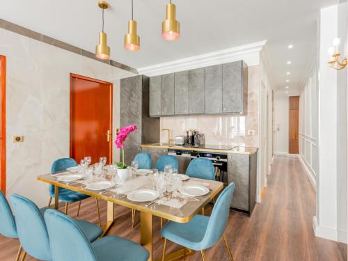 une salle à manger avec une table et des chaises bleues dans l'établissement Merveil -Luxury Serviced Apartment-Saint Martin II, à Paris