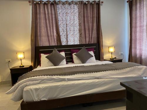 a bedroom with a large bed with two lamps at Hotel Rajshree Palace in Gupta Kāshi