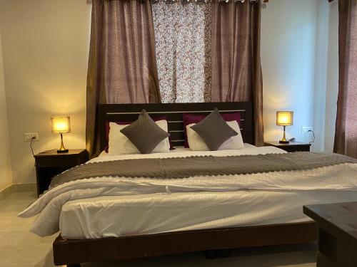 a bedroom with a large bed with two lamps at Hotel Rajshree Palace in Gupta Kāshi
