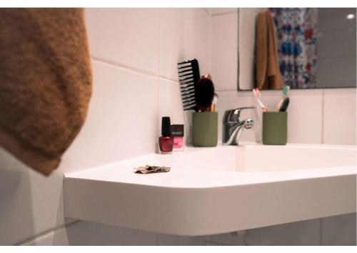 - un lavabo avec 2 brosses à dents et un miroir dans l'établissement Résidence Nemea Montecristo, à Nantes