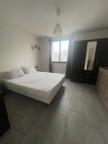 une chambre avec un grand lit blanc et une fenêtre dans l'établissement Confort, à la mer, tout à pied !, à Six-Fours-les-Plages