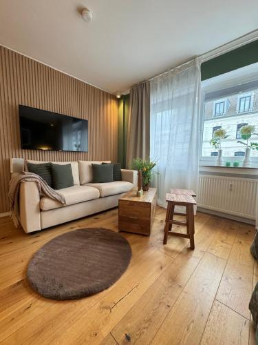 a living room with a couch and a large window at Nettes Appartment in Düsseldorf-Derendorf - stylisch + gemütlich in Düsseldorf