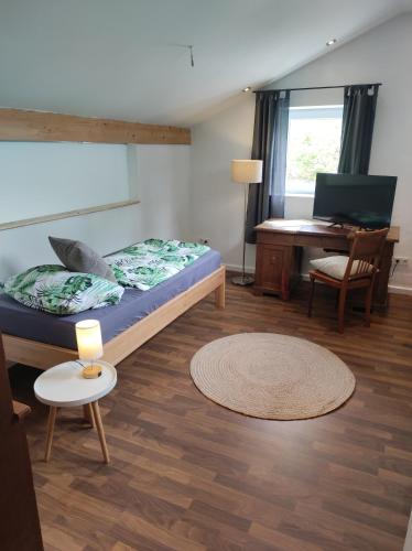 a bedroom with a bed and a table and a desk at Bungalow mit 200 qm Wohnfläche :) in Birgland