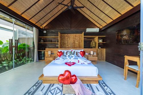 a bedroom with a white bed with red flowers on it at Villa Bolon in Kuta