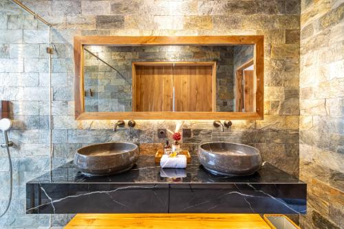 two sinks in a bathroom with a mirror at Villa Bolon in Kuta