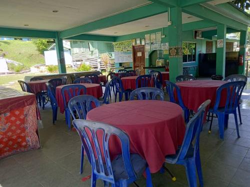 a group of tables and chairs with red and blue tables at Ulu River Lodge, Riverbug Perak in Gopeng