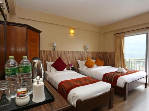 a hotel room with two beds and a balcony at Pokhara Crown Plaza in Pokhara