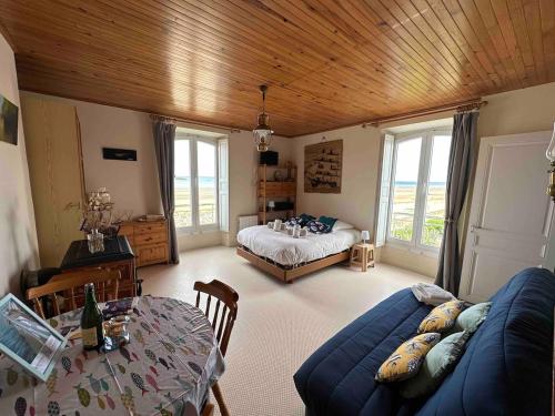 - un salon avec un canapé bleu et un lit dans l'établissement L'Horizon Bleu, front de mer, jardin, parking, wifi, à Asnelles