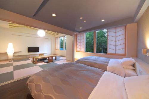 a bedroom with a large bed and a tv at Kusatsu Skyland Hotel in Kusatsu