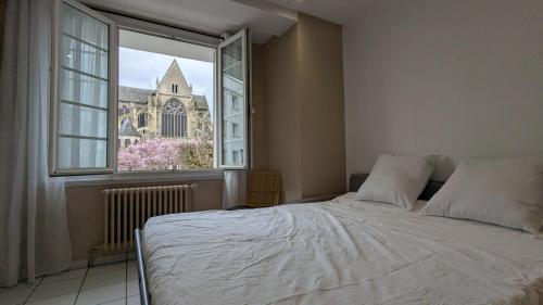 - une chambre avec un lit et une fenêtre avec une église dans l'établissement KnP Voltaire Tours, à Tours
