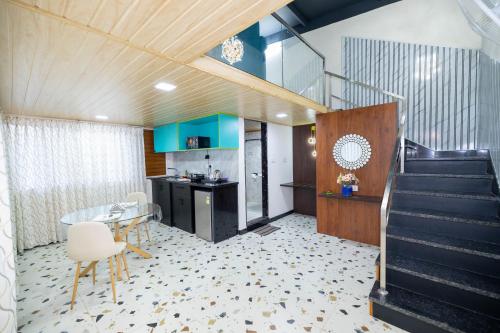 a lobby with a staircase and a table and chairs at Solandis Service Apartment in Manipala