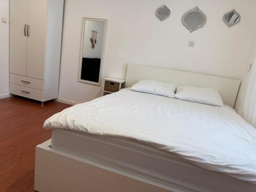 a bedroom with a large white bed with white sheets at סתלבט בקיבוץ in Hagoshrim