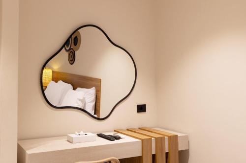 a mirror on a wall above a table with a bed at La Boutique Hôtel - Vue Des Pyramides in Cairo