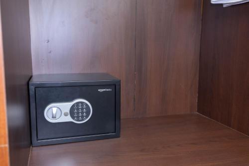 a microwave oven sitting on top of a wooden wall at Solandis Service Apartment in Manipala