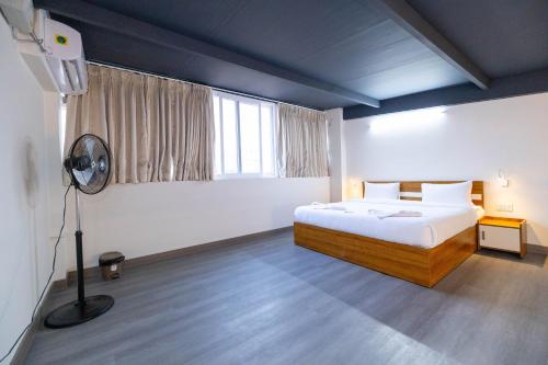 a bedroom with a bed and a fan in it at Solandis Service Apartment in Manipala