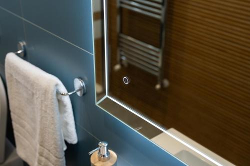 a bathroom with a mirror and a sink with towels at Villa Cola - Vesuvio Garden & Relax in Boscotrecase