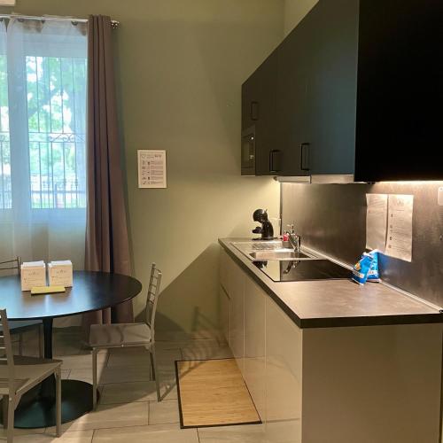a kitchen with a sink and a table at Bnbook Residence La Red in Rho