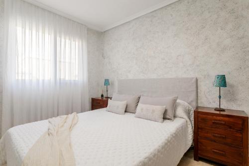 a bedroom with a white bed and a window at Legado Marino in Santa Pola