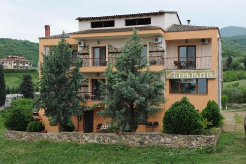 a building with trees in front of it at Ξενώνας Κερκινίτης in Lithótopos