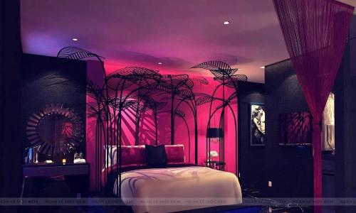 a bedroom with a bed with pink lighting at Ngan Le Mot Dem Hotel - Khach San 1001 Unique Love Hotel in Ho Chi Minh City