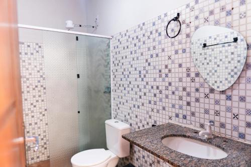 a bathroom with a toilet and a sink and a shower at Recanto dos Pássaros Refúgio com piscina e lazer in Pôrto Feliz