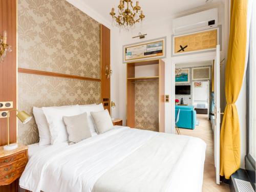 - une chambre avec un lit blanc et un rideau jaune dans l'établissement Merveil - Luxury Suite - Louvre - Reaumur II, à Paris