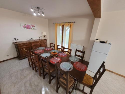 a dining room with a table and chairs and a refrigerator at Grande maison à la campagne in Bourgnac