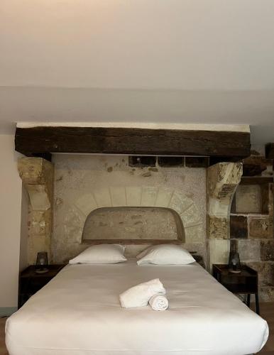 une chambre avec un grand lit avec un mur en pierre dans l'établissement La Maison Tanneur, centre ville historique à 5mn de Beauval, à Saint-Aignan