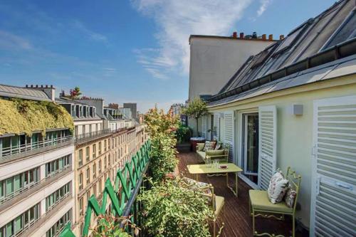 Cet appartement dispose d'un balcon avec une table et des chaises. dans l'établissement Ultra luxe et Confort au Coeur des champs-Elysees, à Paris