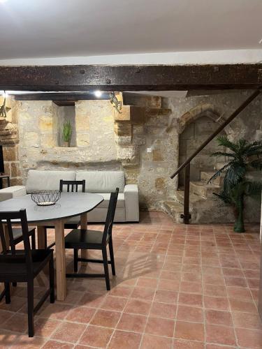 - un salon avec une table et une cheminée en pierre dans l'établissement La Maison Tanneur, centre ville historique à 5mn de Beauval, à Saint-Aignan