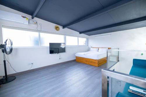 a room with a bed and a television in it at Solandis Service Apartment in Manipala