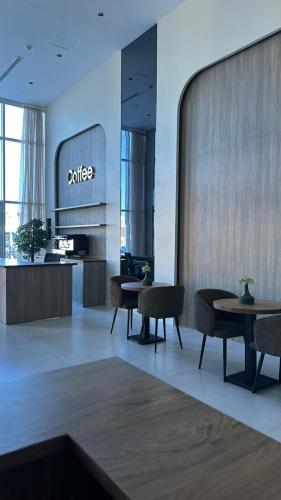a lobby with tables and chairs in a building at فندق سفن جاردنز - المطار in Taif