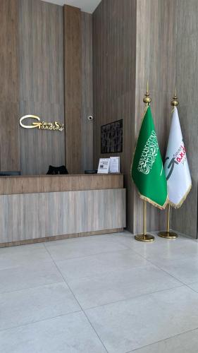 a lobby with a green and white flag next to a counter at فندق سفن جاردنز - المطار in Taif