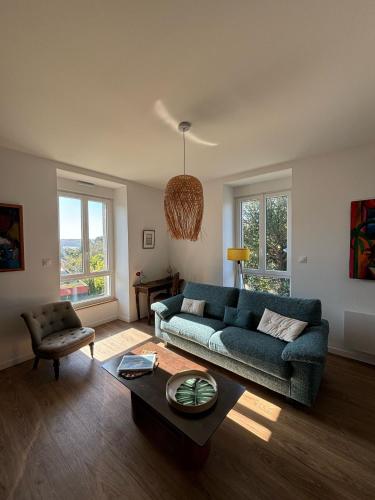 a living room with a blue couch and a table at Maison de Kerangall Brest appartement jardin et parking in Brest